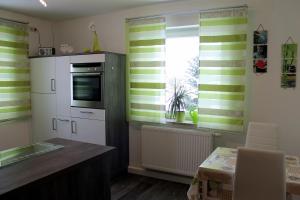 a kitchen with green and white striped walls and a window at Ferienwohnung Geyer in Penzing