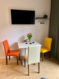 Biały stół z dwoma krzesłami i wazon kwiatów w obiekcie Townhouse Apartment Potsdam w Poczdamie