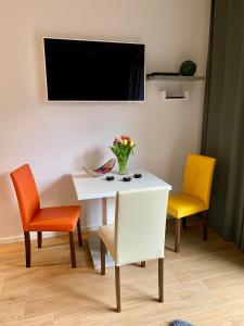 a white table with two chairs and a vase of flowers at Townhouse Apartment Potsdam in Potsdam
