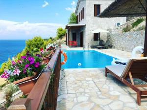 a house with a swimming pool next to the ocean at Milos Paradise Luxury Villas in Agios Nikitas