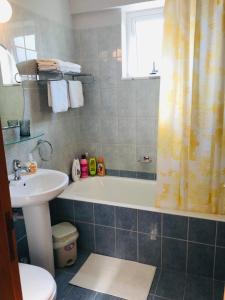 a bathroom with a tub and a sink and a toilet at Pool Apartment in Larnaca