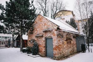 a brick building with a door in the snow at Penzión Dobré Časy in Poprad