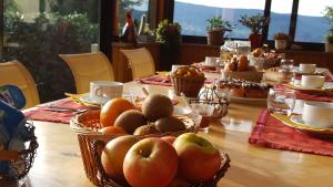 una mesa con fruta en cestas encima en Les Hauts du Lac, en Gérardmer