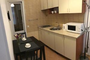 a small kitchen with a sink and a microwave at Charming apartment in Odesa