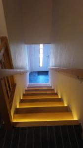 a hallway with stairs with a light at the top at Zimmer vor Sylt und Dänemark in Klanxbüll