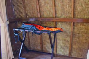 una mesa frente a una pared con una bolsa. en Butterfly Bungalow, en Nusa Penida