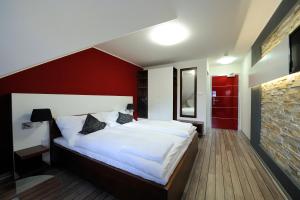 ein Schlafzimmer mit einem weißen Bett und einer roten Wand in der Unterkunft Caramell in Louny
