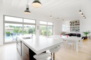 une cuisine avec comptoirs blancs et une grande fenêtre dans l'établissement Les Crays de Levigny, à Charnay-lès-Mâcon