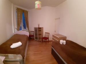 Pokój z 2 łóżkami, stołem i krzesłami w obiekcie Belleview Apartments w mieście Tbilisi City
