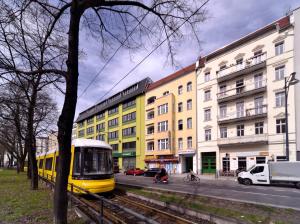 a yellow train on the tracks in front of a building at Old Town Hotel in Berlin