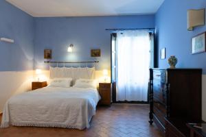 a bedroom with a white bed and white walls at Villa Trigona in Piazza Armerina
