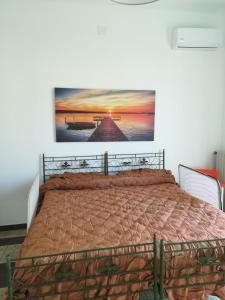 a bedroom with a bed with a picture on the wall at Villa Ada in Torre Colimena