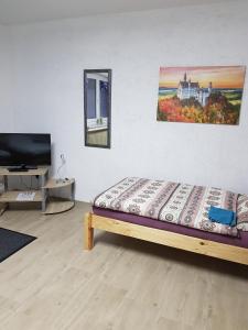 Bett in einem Zimmer mit TV und Avertisation in der Unterkunft Stabel Zimmervermietung in Lingen