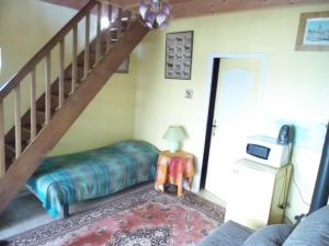 a living room with a couch and a stair case at L' écrin de Pradou Glas in Le Saint