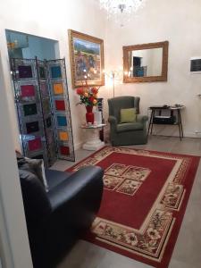 da Ysabel في فيرونا: غرفة معيشة مع أريكة وكرسي وسجادة