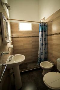 Un baño con lavabo, inodoro y ducha. en Casa en Balneario Sol y Rio, en Villa Carlos Paz