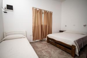 1 dormitorio con 2 camas y ventana en Casa en Balneario Sol y Rio en Villa Carlos Paz