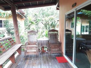 a patio with a table and chairs on a deck at JJ Beach Resort & JJ Seafood in Ko Phayam