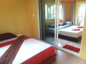 a bedroom with two beds and a mirror at JJ Beach Resort & JJ Seafood in Ko Phayam