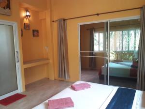 a bedroom with a bed and a sliding glass door at JJ Beach Resort & JJ Seafood in Ko Phayam