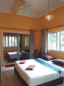 two beds in a room with orange walls at JJ Beach Resort & JJ Seafood in Ko Phayam