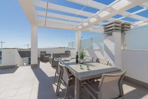 a patio with a table and chairs on a roof at Calle Bullas Topfloor lejlighed in Torrevieja