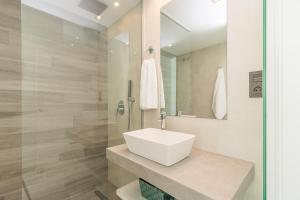 a bathroom with a white sink and a shower at Calle Bullas Topfloor lejlighed in Torrevieja +17 photos