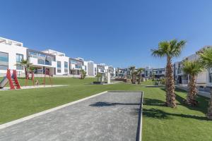 a playground in a park with palm trees and buildings at Calle Bullas Topfloor lejlighed in Torrevieja