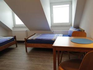 ein kleines Zimmer mit 2 Betten, einem Tisch und einem Tisch in der Unterkunft Haus St. Josef in Vallendar