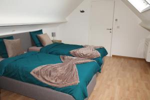 Vakantiewoning Leberg في براكيل: غرفة نوم بسريرين عليها بطانيات