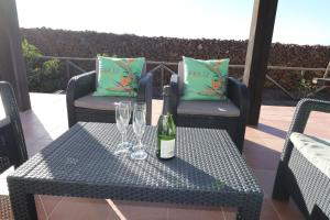 une bouteille de vin posée sur une table avec deux verres dans l'établissement Villa Flora, à Lajares