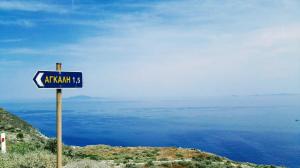 a blue sign on the side of a hill with the ocean at Perigiali Rooms & Apartments Folegandros in Agali