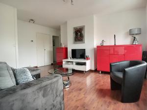 a living room with a couch and red cabinets at Echapée belle proche gare et centre ville in Chalons en Champagne