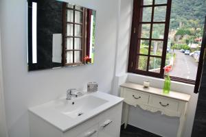 a bathroom with a sink and a mirror and a window at Solar Arco de São Jorge in Santana