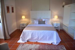 1 dormitorio con 1 cama grande y 2 mesitas de noche en Solar Arco de São Jorge, en Santana
