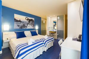 
a hotel room with two beds and a television at Ur-Alde in San Sebastián
