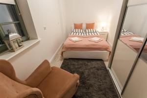 mała sypialnia z łóżkiem i lustrem w obiekcie Apartament Rynek Sienny 1 w Szczecinie