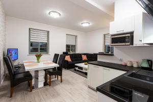 kuchnia i salon ze stołem i krzesłami w obiekcie Apartament Rynek Sienny 1 w Szczecinie