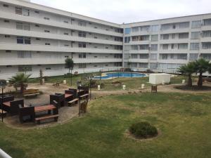 un edificio de apartamentos con un parque con bancos y una piscina en Departamento en playa, en La Serena