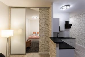 a kitchen with a sliding glass door leading to a bedroom at Apartament Rynek Sienny 1 in Szczecin