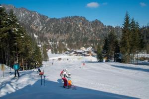 a group of people skiing down a snow covered slope at Burnout Wildalps in Wildalpen