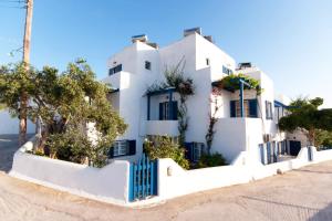 a white house with trees in front of it at Angeliki's Studios Paros in Parikia
