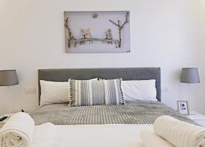um quarto com uma cama grande e almofadas brancas em EXCLUSIVO Y LUMINOSO PISO EN EL PARQUE DEL RETIRO em Madri