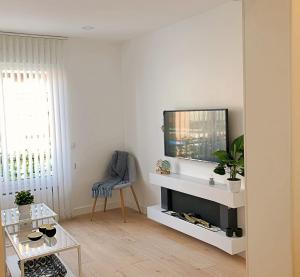 a living room with a flat screen tv above a fireplace at EXCLUSIVO Y LUMINOSO PISO EN EL PARQUE DEL RETIRO in Madrid