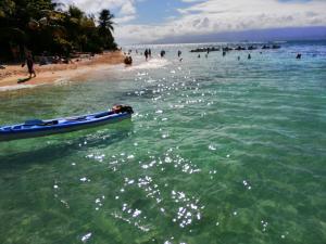 - un bateau sur l'eau à la plage dans l'établissement Location proche plage, au Gosier