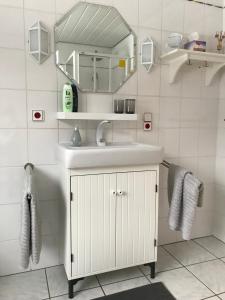 a white bathroom with a sink and a mirror at Ferienwohnung Haus Friederike ab 6 Übernachtungen, inclusive Meine Card Plus in Willingen
