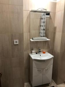 a small bathroom with a sink and a mirror at Rózsa Apartmanház in Szeged