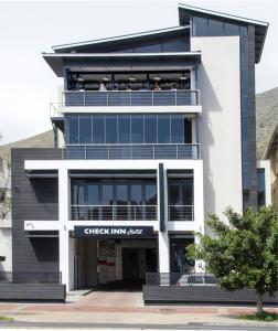 a building with people sitting on the balconies of it at Check Inn Hotel in Cape Town