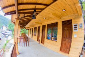 Tea Breeze Motel في نالاثانيا: مبنى خشبي مع شمسية وطاولات وكراسي