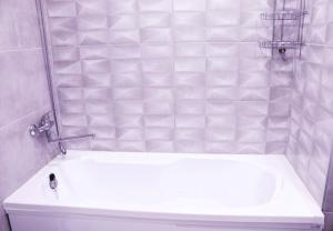a bathroom with a white tub and a sink at Butas miesto centre in Panevėžys
